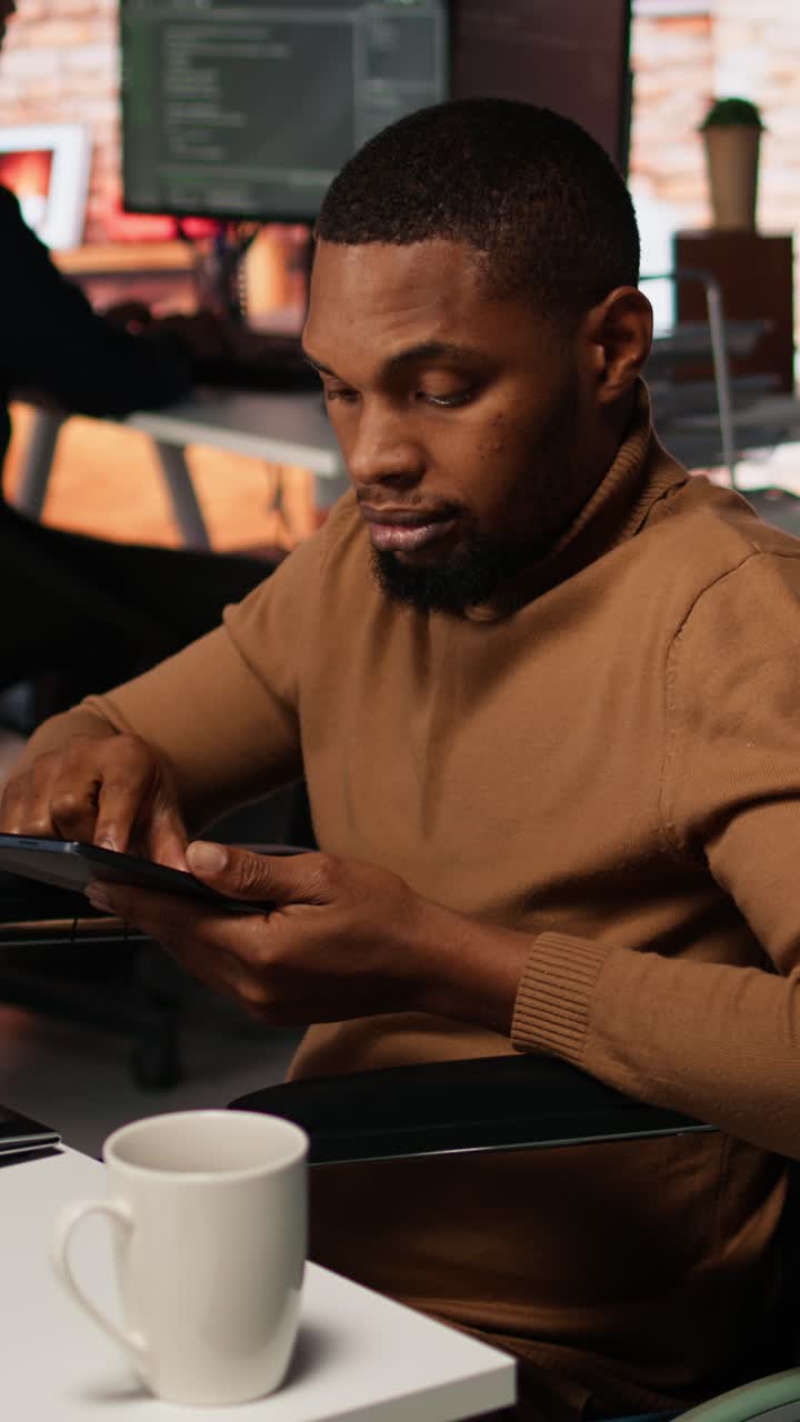 Vertical video Inclusive software development agency worker with paraplegia uses tablet
