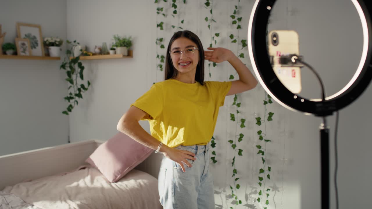 Ragazza adolescente caucasica che balla e registra un video per i social media usando una ring light.