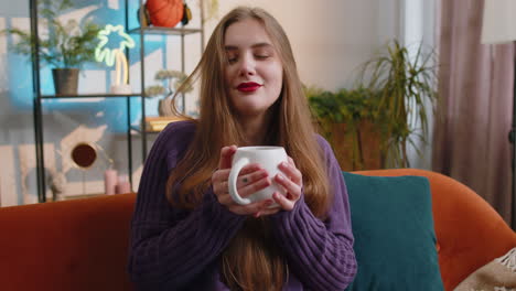 a woman sitting on a couch holding a cup of coffee