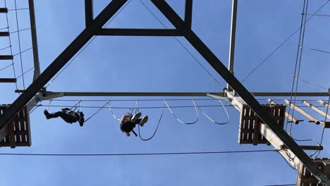 Unerschrockene-Kinder,-Die-Sich-Mit-Einer-Hängenden-Seilbrücke-An-Der-Holzstruktur-Des-Abenteuerparks-Amüsieren