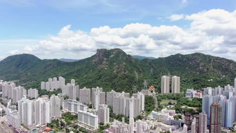 Mega-residential-buildings-in-downtown-Hong-Kong-and-Lion-rock-mountain-ridge-in-the-background,-Aerial-view