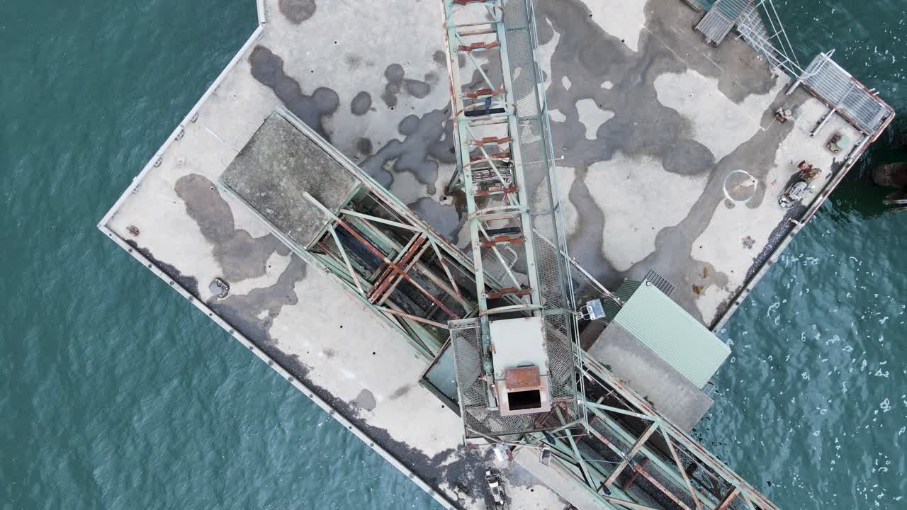 바다로 둘러싸인 오래된 버려진 석탄 선적 부두와 플랫폼의 클로즈업 보기