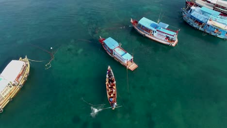 longtail boat arrive with people to bigger boat on the water thailand