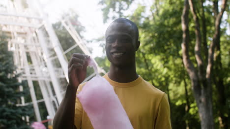 young man eating candy floss