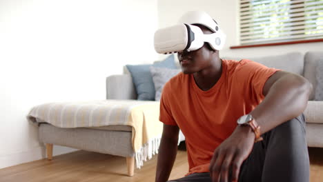 using vr headset, african american man on floor, enjoying virtual reality, at home, copy space