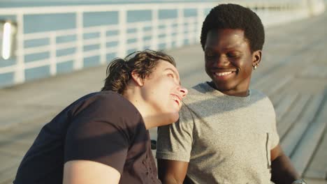 portrait of happy couple using wheelchairs on bridge