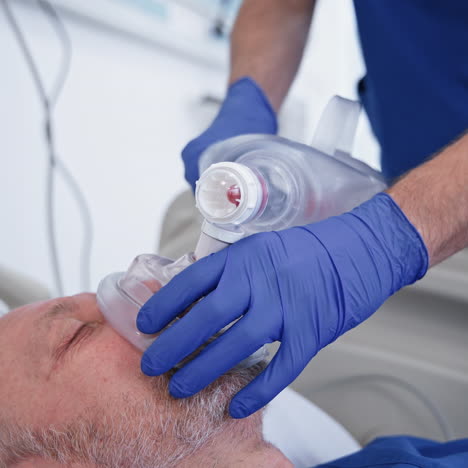 doctor gives resuscitation to a male patient. oxygen mask on patient's face in the emergency room. reanimation. close-up.
