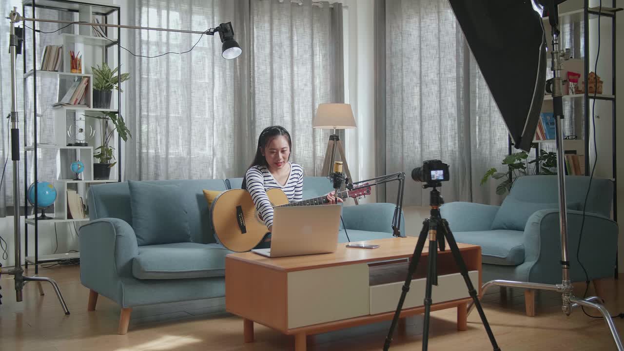 가정 스튜디오 에서 기타 를 연주 하는 여자