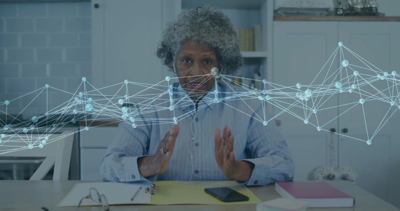 Senior woman speaking in office, gesturing while tech network overlay highlighting phone data
