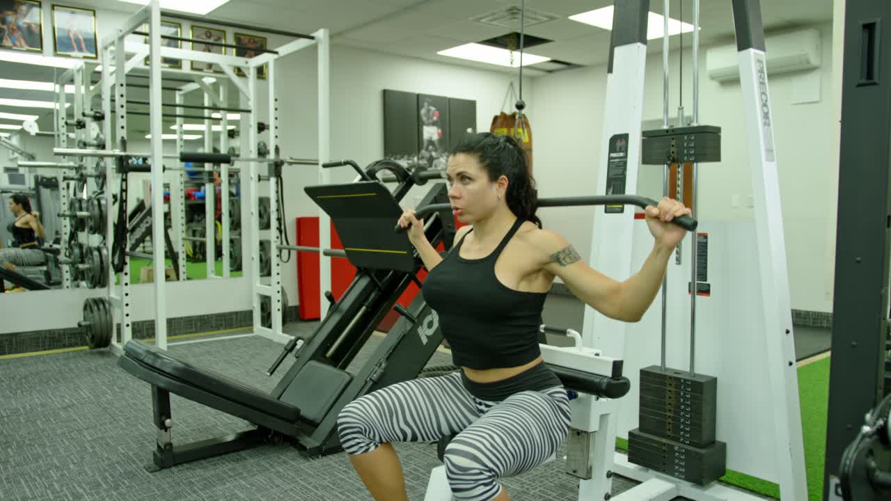 Female with muscular body exercise in training gym