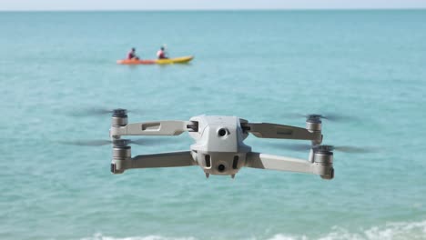 dron flotando en una playa con el océano de fondo