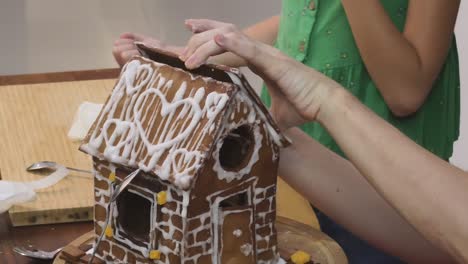 children decorating a gingerbread house