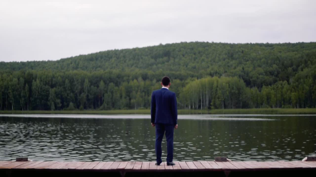 호수 를 내려다보는 나무 의 도크 에 서 있는 신부