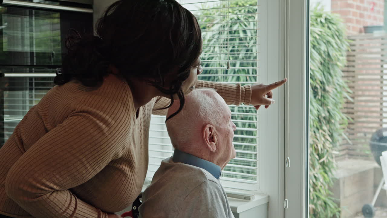 Caregiver assisting senior man in wheelchair