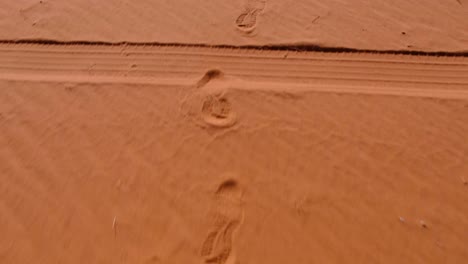 footprints left in red sandy desert of wadi rum in jordan, middle east, from a person walking through the vast, remote wilderness