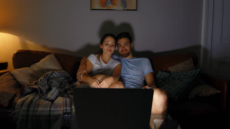 couple watching movie on laptop at home 4k