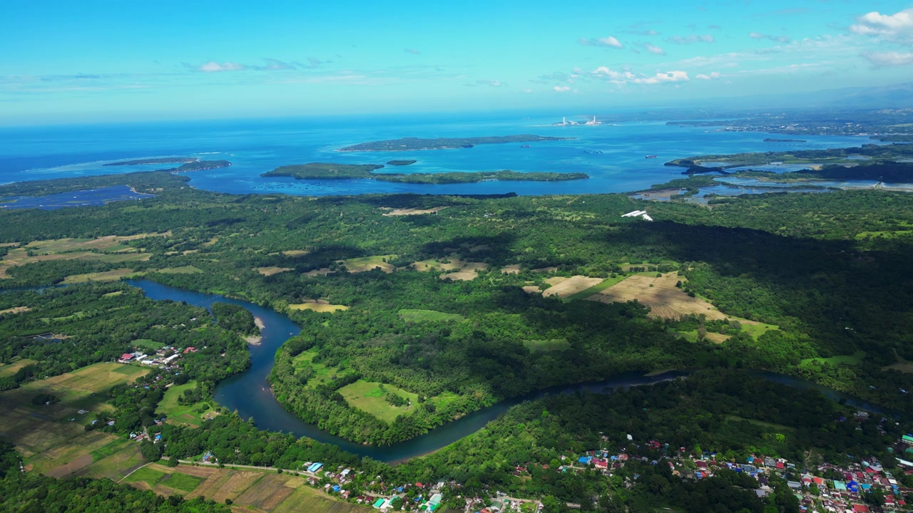 Wide aerial shot showing Salasa River flowing through rural land in Tition, San Vicente under clear tropical skies.