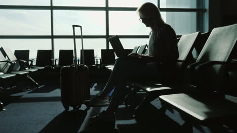 Geschäftsfrau-Mit-Laptop-Im-Flughafenterminal