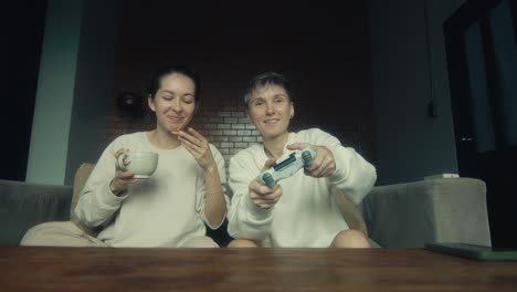 two women relaxing at home and gaming together