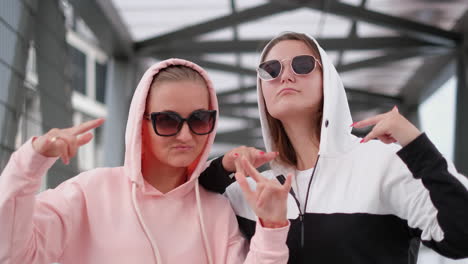 two sisters dance hip hop the show gestures with his hands two sisters dance hip hop the show gestures with his hands young girls wearing sweaters with hoods on their heads cheerful mood of the girls