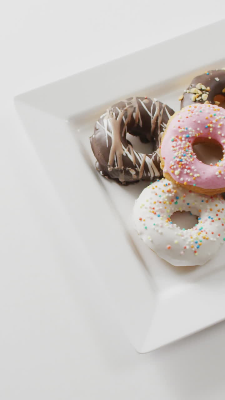 video de rosquillas con glaseado en una placa blanca sobre un fondo blanco