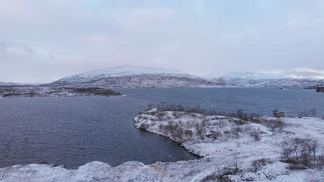 Paisaje-Inhóspito-Congelado-Junto-Al-Lago-Cerca-De-La-Frontera-Entre-Noruega-Y-Suecia---Sobrevuelo-Aéreo-De-ángulo-Bajo