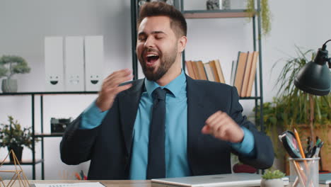 caucasian businessman sitting at office workplace desk closing laptop pc after finishing remote work