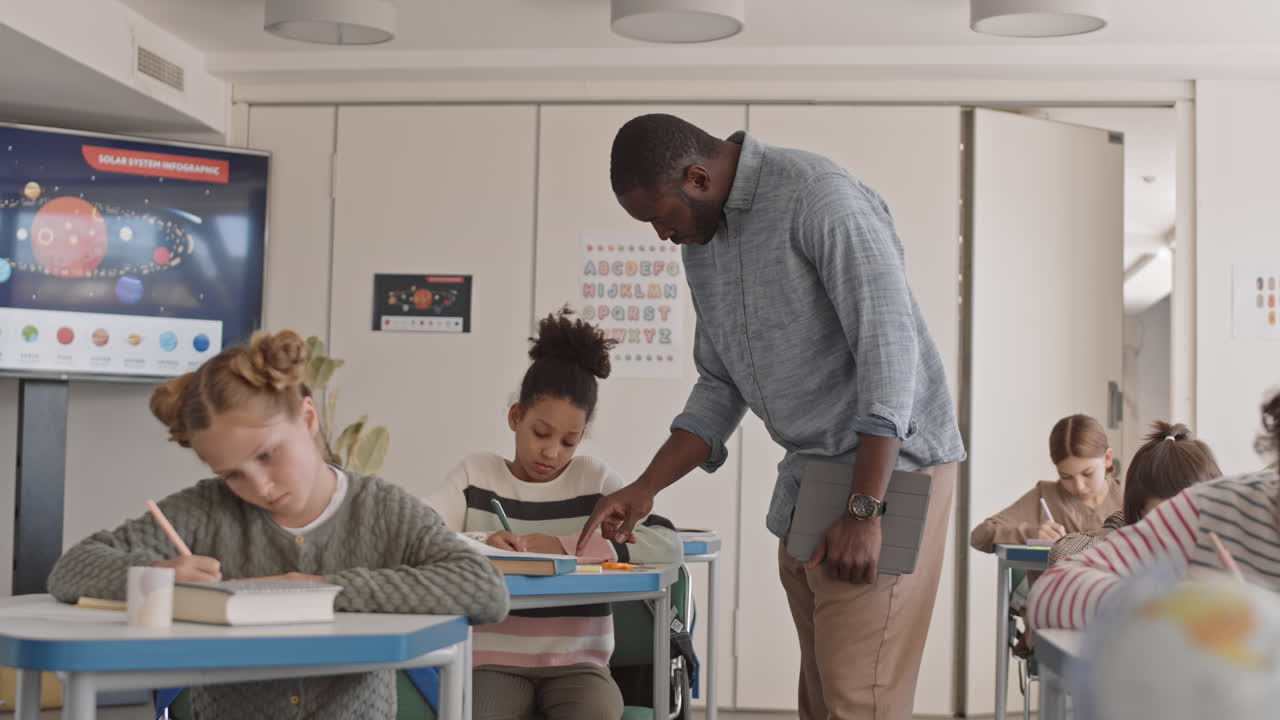 Insegnante afroamericana aiuta una studentessa durante l'esame