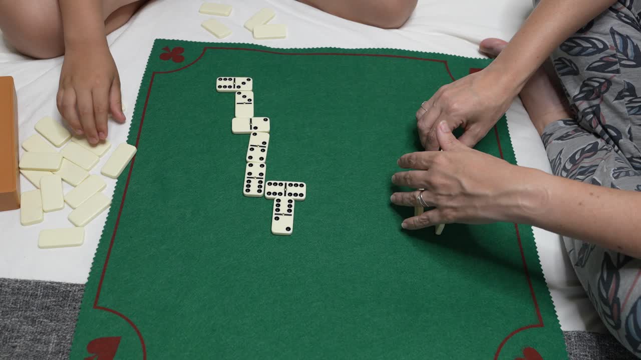 Famiglia che gioca a domino su un tappetino verde da gioco da tavolo
