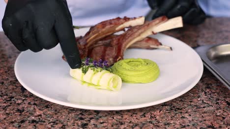 chef preparando chuletas de cordero gourmet con puré verde