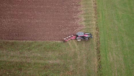 wide aerial shot of a tractor plowing fields