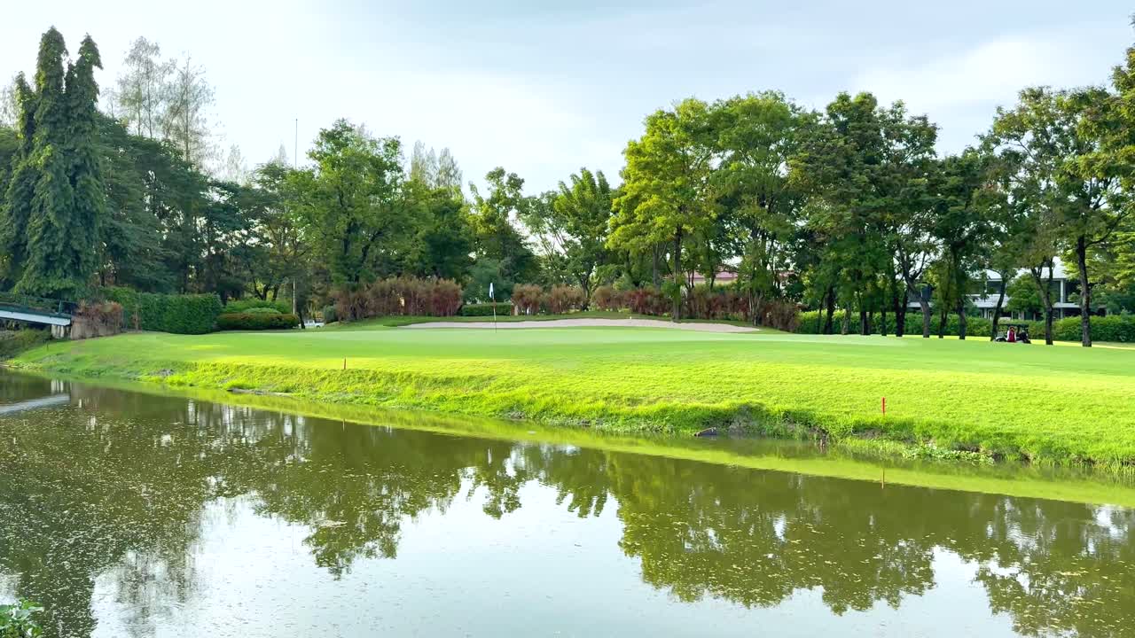 골프 코스에서 나무를 반영하는 조용한 연못