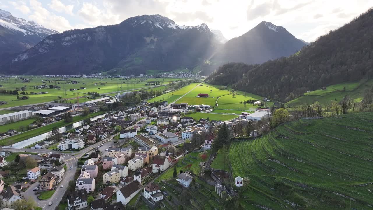 puesta de sol sobre weesen, suiza, mostrando un pueblo enclavado entre colinas y montañas exuberantes