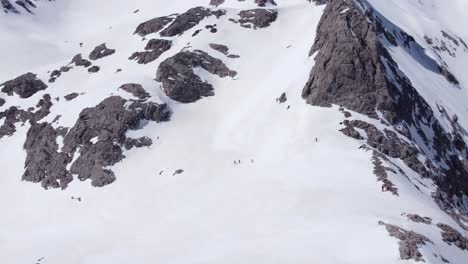 Anonymous-travelers-walking-on-Picos-de-Europa-mountains-covered-with-snow