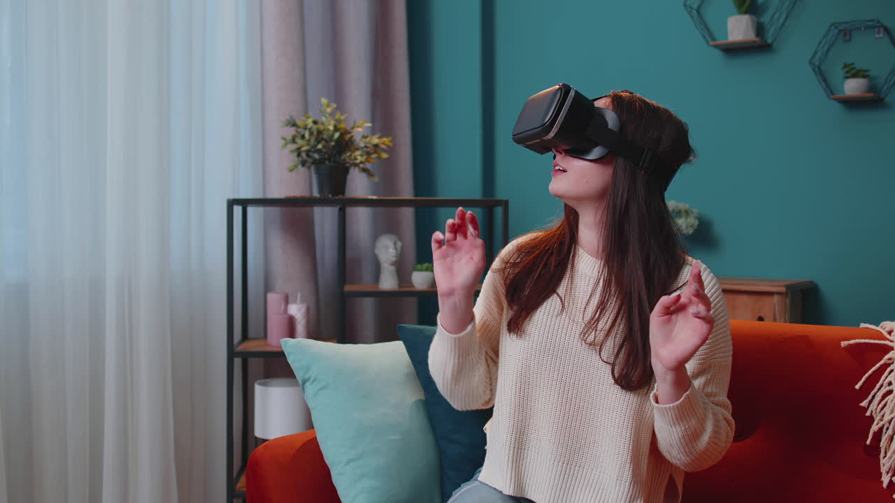 Ragazza giovane usa occhiali di realtà virtuale a casa gioca a videogiochi 3D facendo gesti con le mani