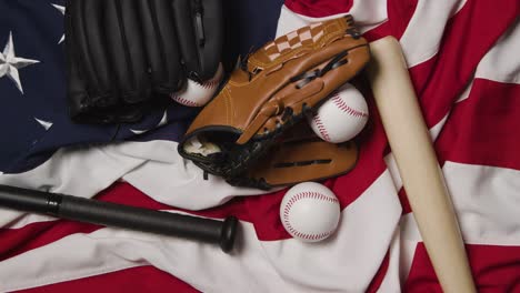 overhead baseball still life with bat and catchers mitt on american flag with person picking up ball 2