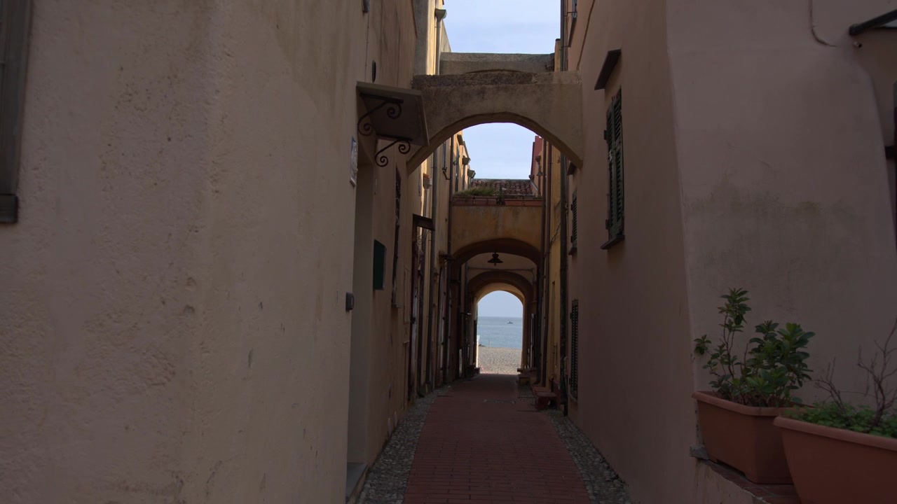 Stretto vicolo mediterraneo con archi a Varigotti, Italia.
