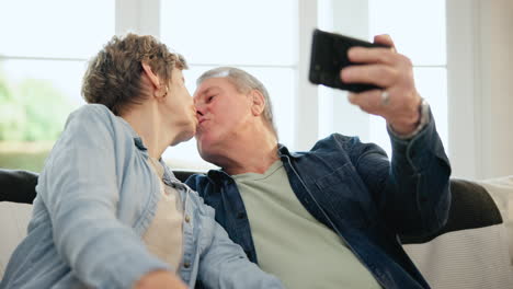 Feliz-Pareja-De-Ancianos,-Selfie-Y-Sofá-Con-Beso