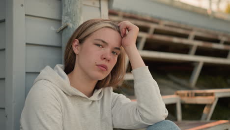 young woman rests her head on her hand, lost in deep contemplation, her expression reveals a mix of introspection and calmness, with warm natural lighting