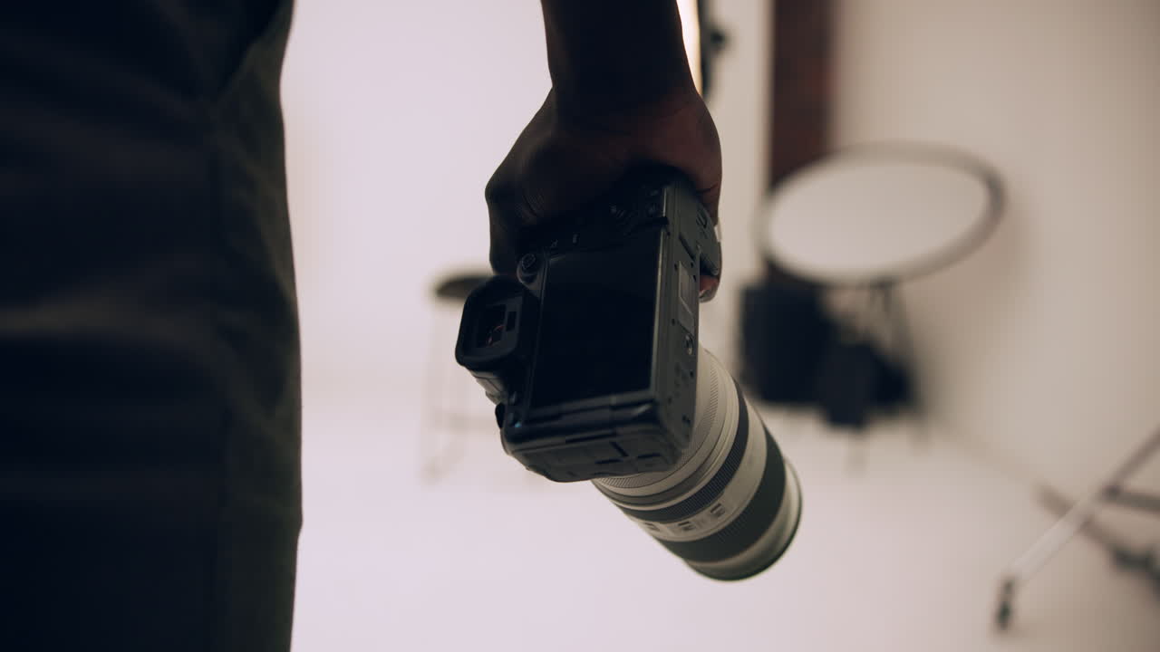 Hand holding a camera in a studio