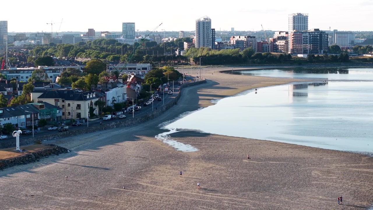 Luftfoto af Sandymount Strand bybillede i aftenlys med Dublins kystlinje og beboelsesområde