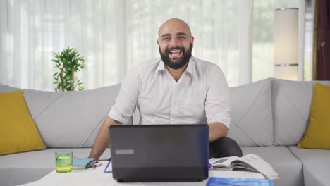 home office worker man smiles at camera.