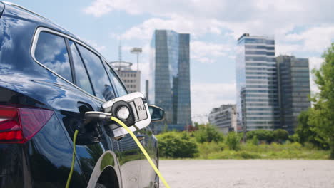 chica desconectando el cable de carga de su coche eléctrico, disparo de mano