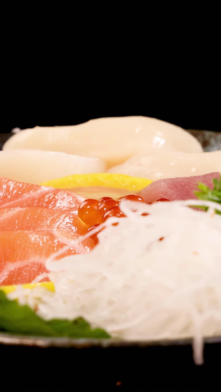 Một đĩa sashimi sống động với cá hồi, cá ngừ, sò điệp, trứng cá hồi và đồ trang trí xoay dưới ánh sáng studio rực rỡ, hé lộ kết cấu tươi ngon và cách bài trí đầy màu sắc.