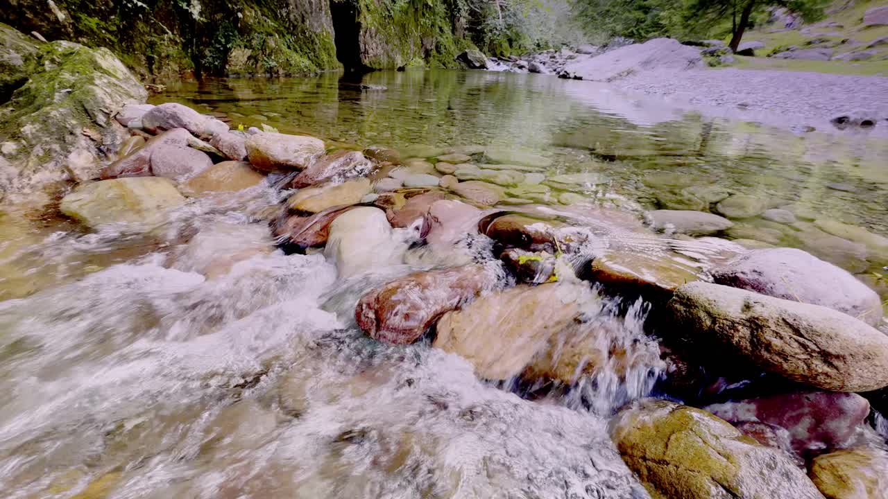 Vildmarkens hvisken, hvor vandet danser over gamle sten. Naturens perfekte strømmende symfoni.