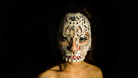 a woman with ornate venetian skull mask over face