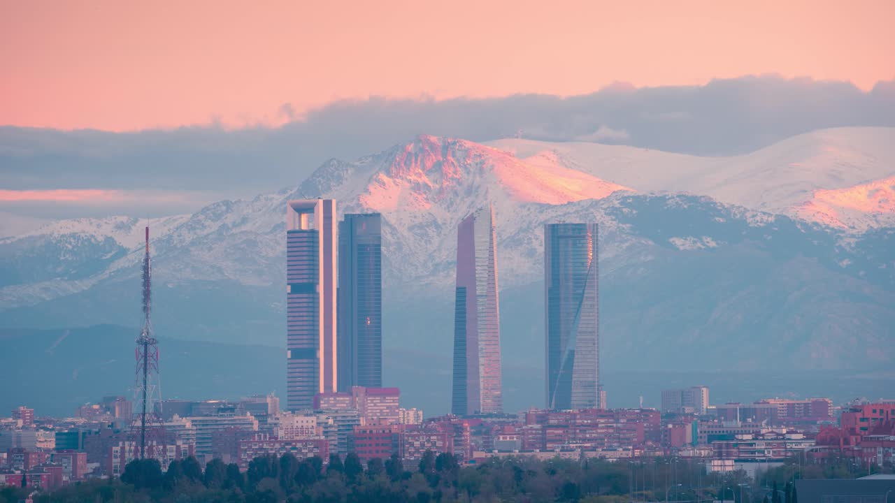 timelapse del horizonte de las 5 torres de madrid y la montaña nevada de la sierra durante el amanecer
