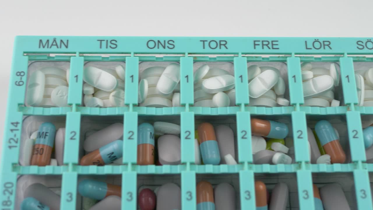 주간 및 시간별 주최자 디스펜서 알약 상자 - 오버헤드 슬라이드 클로즈업 샷