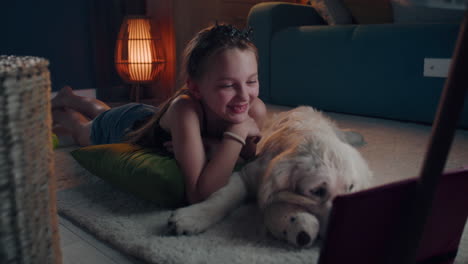 girl and dog relaxing and watching tablet