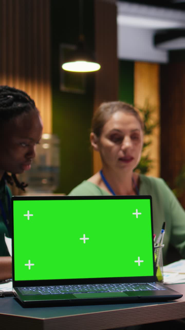 Vertical Video Diverse project team meeting after hours next to mockup display